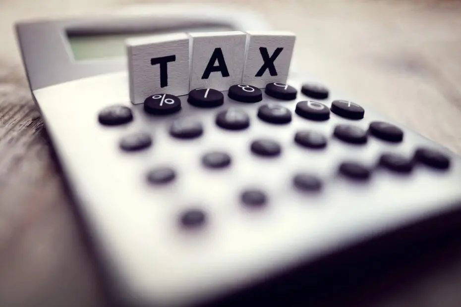 letter blocks spelling out "Tax" on top of a calculator