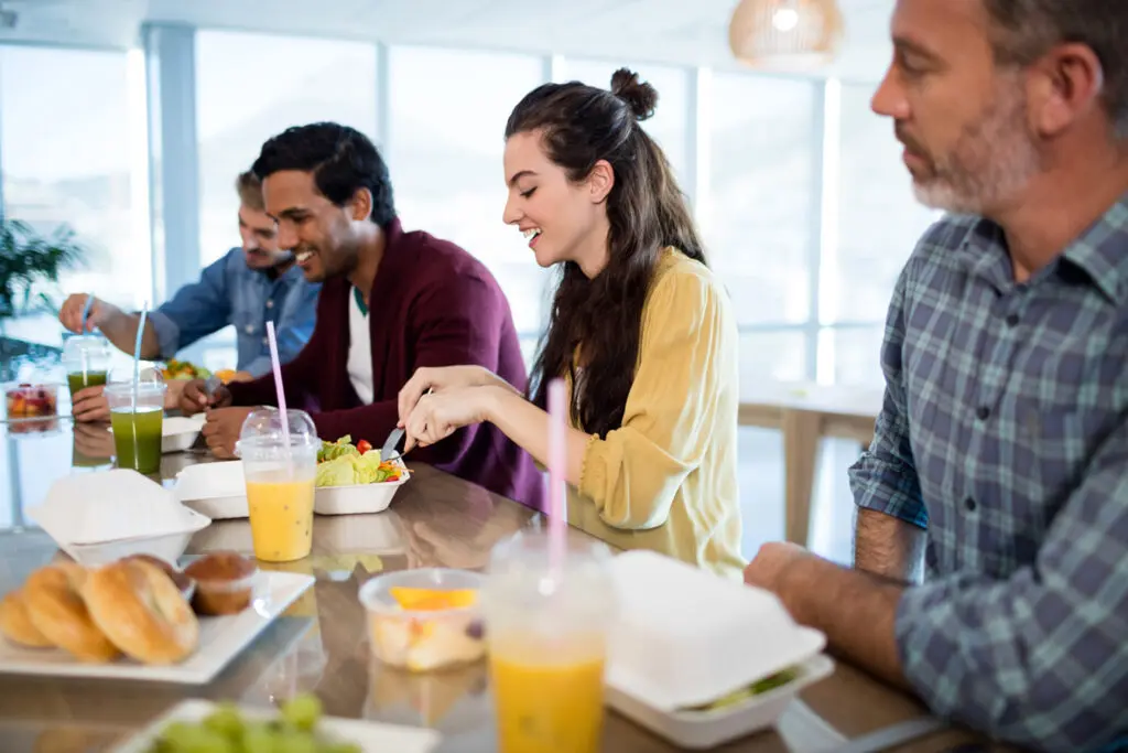 Employees enjoy lunch together with meal provided by their company