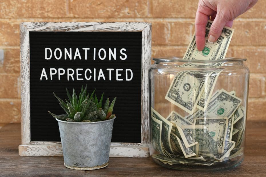 jar of money with donations appreciated sign next to a small potted plant